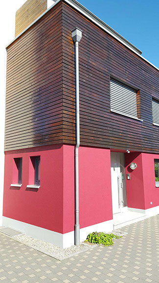 Außenanstrich einer Hausfassade mit rotem Putz und Holzverkleidung in Nürnberg