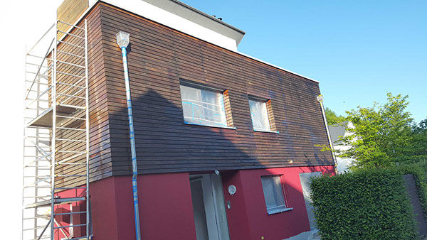 Sanierung einer Holzfassade mit Gerüst während der Fassadenarbeiten